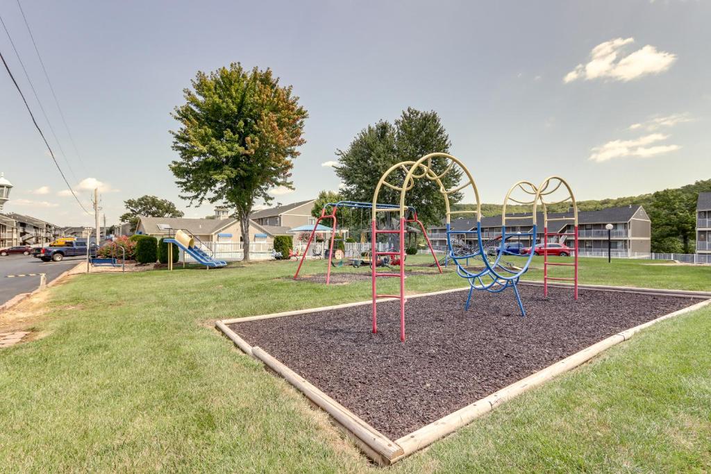 a park with a playground in the grass at Lake and Pool Access Lazy Days Condo with Balcony! in Osage Beach