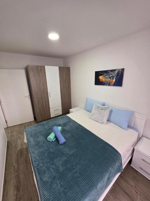 a bedroom with a bed with a blue foot board on it at Apartmani Kostić 3 in Bukorovac