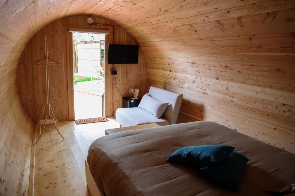 una camera con un letto e una sedia di Rifugio DiVino - Dormire in una Botte - Esperienza unica di Glamping a Castelfranco