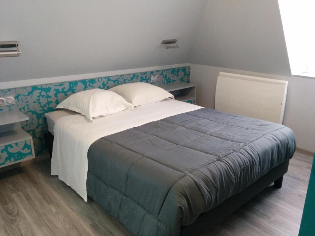 - une chambre avec un grand lit et un mur aux motifs bleus dans l'établissement Hôtel de la Grotte, à Aix-les-Bains
