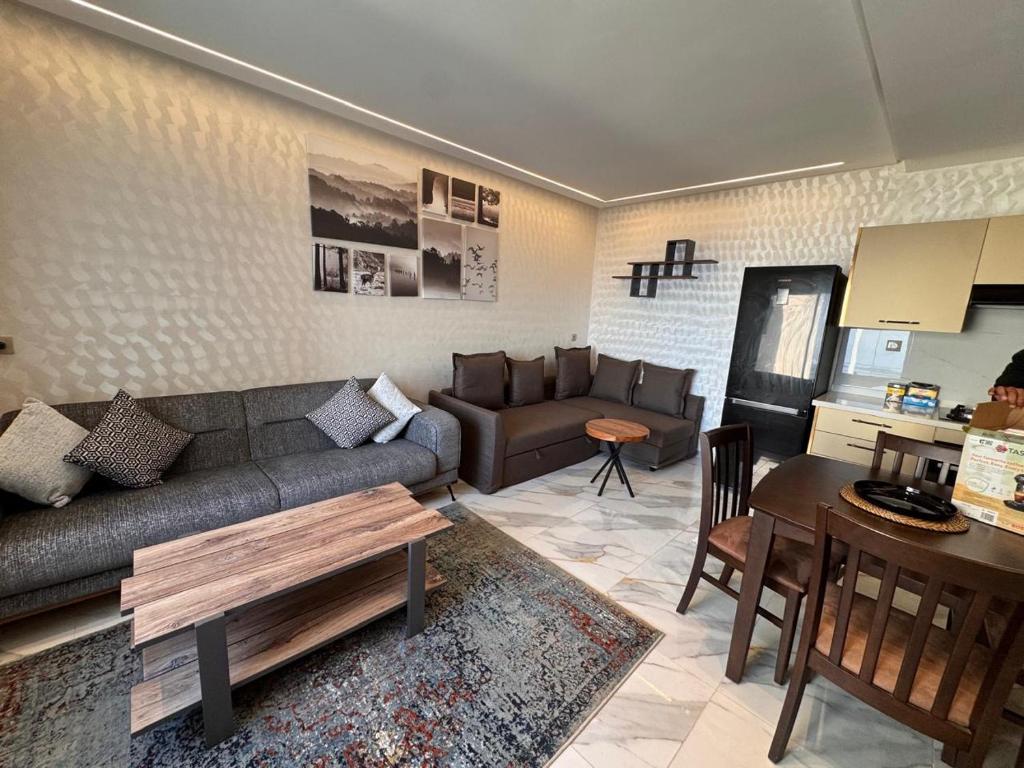 Bel appartement face là mer في القنيطرة: غرفة معيشة مع أريكة وطاولة