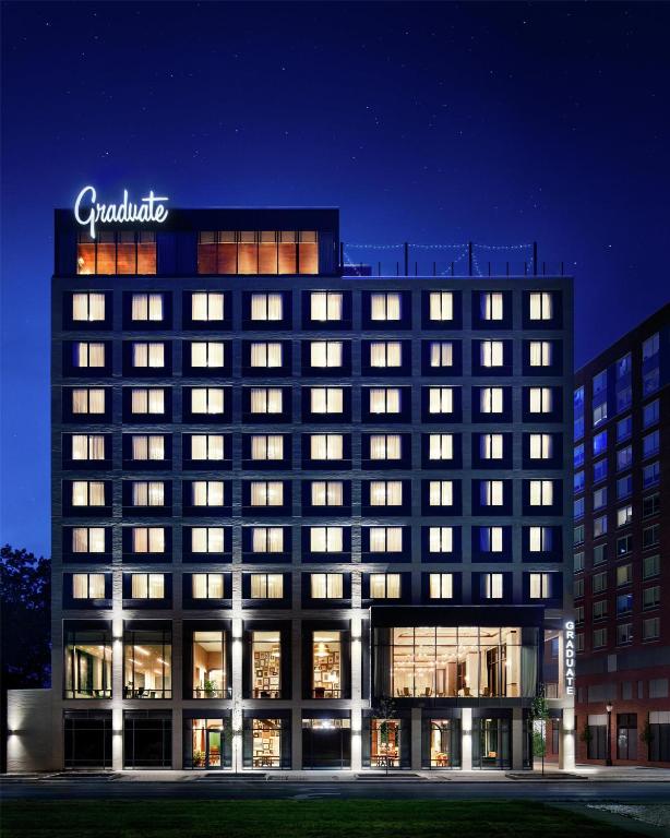 a building with a sign on top of it at night at Graduate by Hilton East Lansing in East Lansing