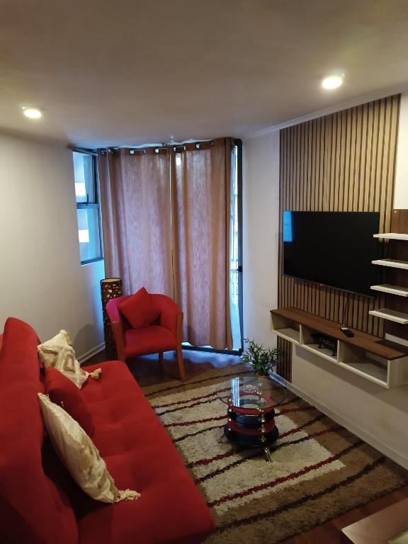 サンティアゴにあるDanyedi Apartのリビングルーム(赤いソファ、薄型テレビ付)