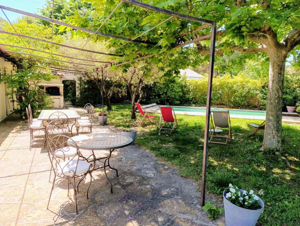 un patio avec une table et des chaises et une piscine dans l'établissement Villa climatisée avec Piscine - Terrain de Pétanque - Proche plage, à Saint-Cyr-sur-Mer