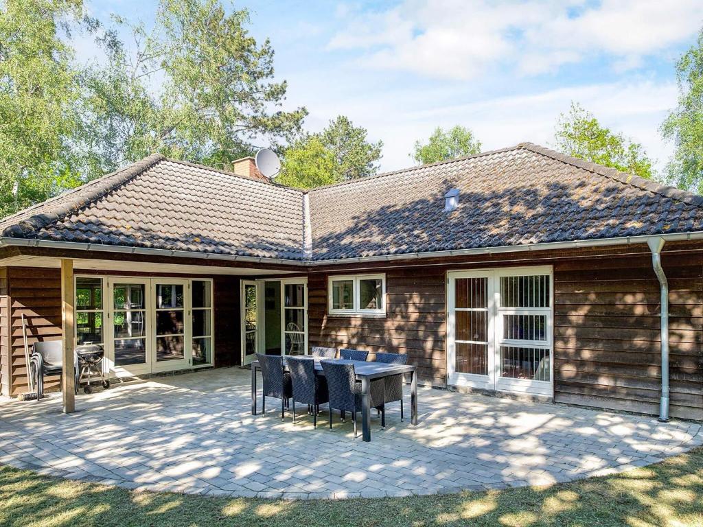 Store FugledeにあるTranquil Beach Retreat - By Traum Ferienwohnungenのテーブルと椅子のあるパティオのある家