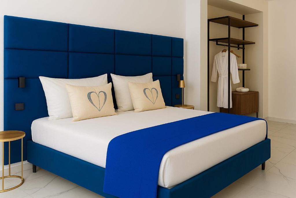 un letto blu con due cuscini con sopra dei cuori di Aries Suite Pompei a Pompei
