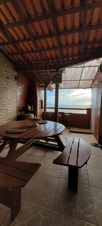 una habitación grande con una mesa y un banco en Apartamento ideal para famílias em mosqueiro, com piscinas e em frente a praia, en Mosqueiro