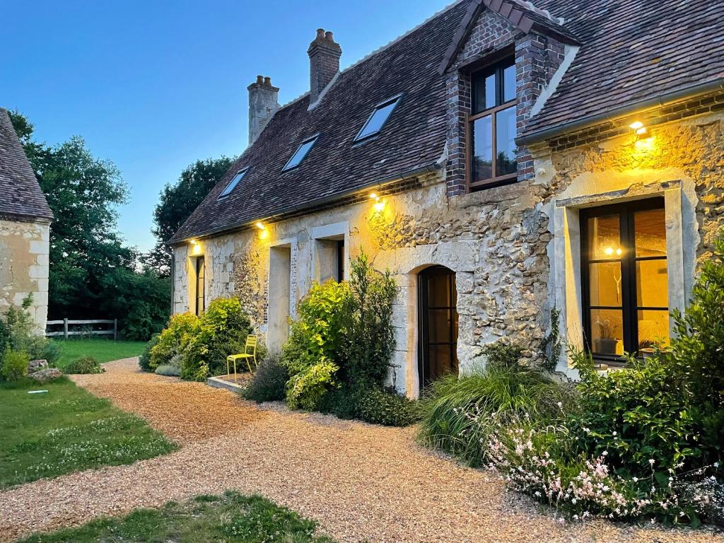 an old stone house with a pathway in front of it at Authentique maison de famille in Val-au-Perche