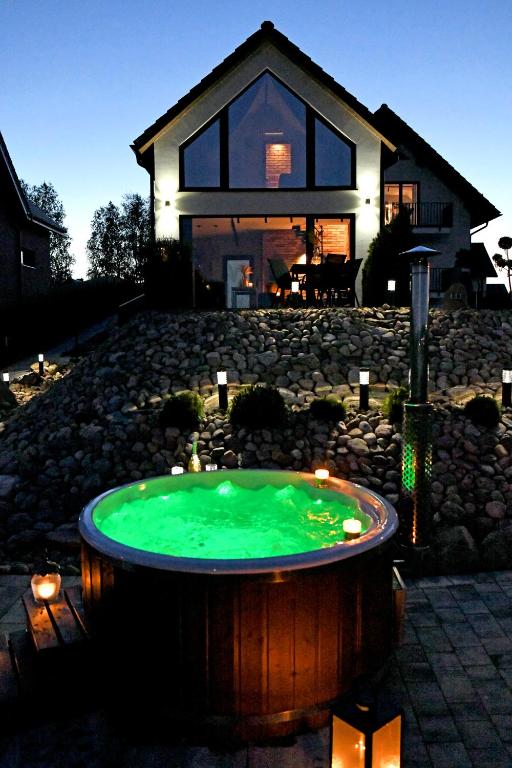 a house with a hot tub in front of a house at APARTAMENT JANETTA domek nad jeziorem in Stężyca