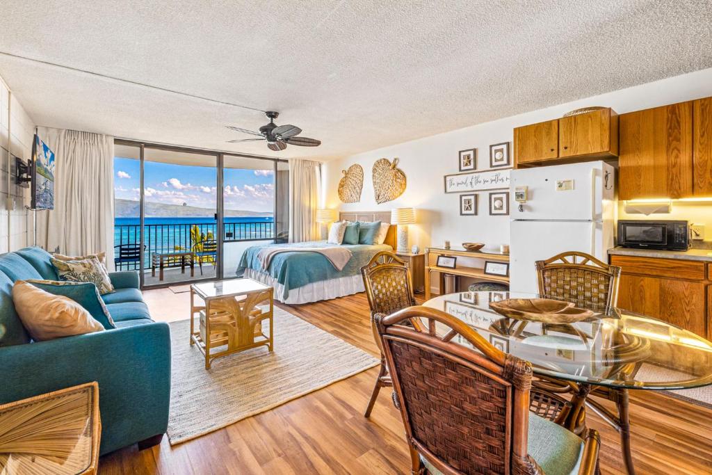 ein Wohnzimmer mit einem Zimmer mit einem Bett und einem Tisch in der Unterkunft Walkers Paradise Maui at Valley Isle Resort in Lahaina