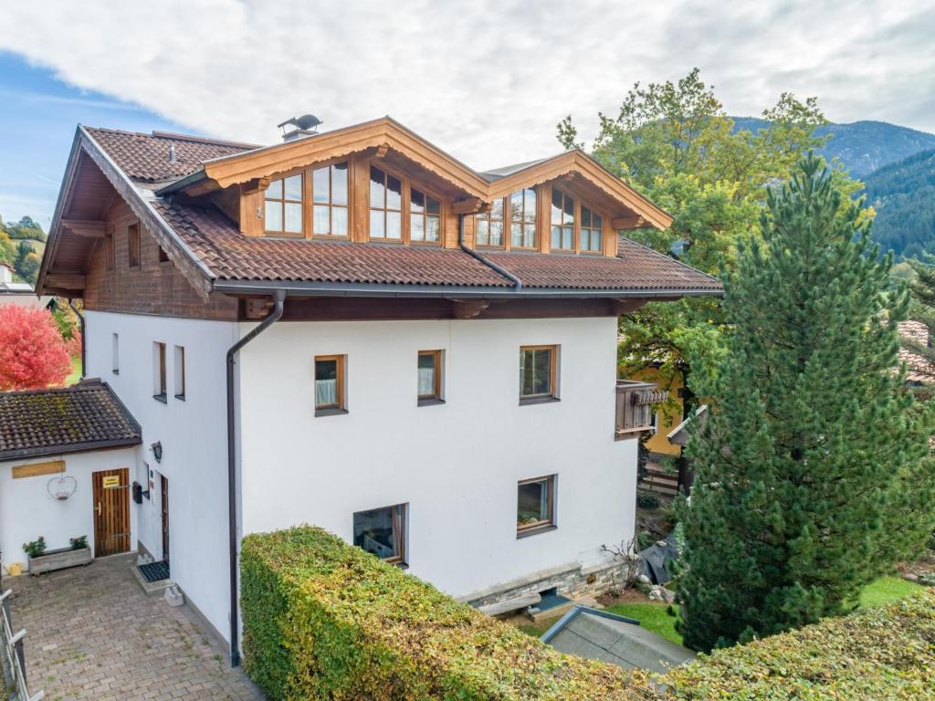 Vue extérieure d'une maison blanche avec un toit en bois dans l'établissement Appartement Brixnerwirt I, à Brixen im Thale