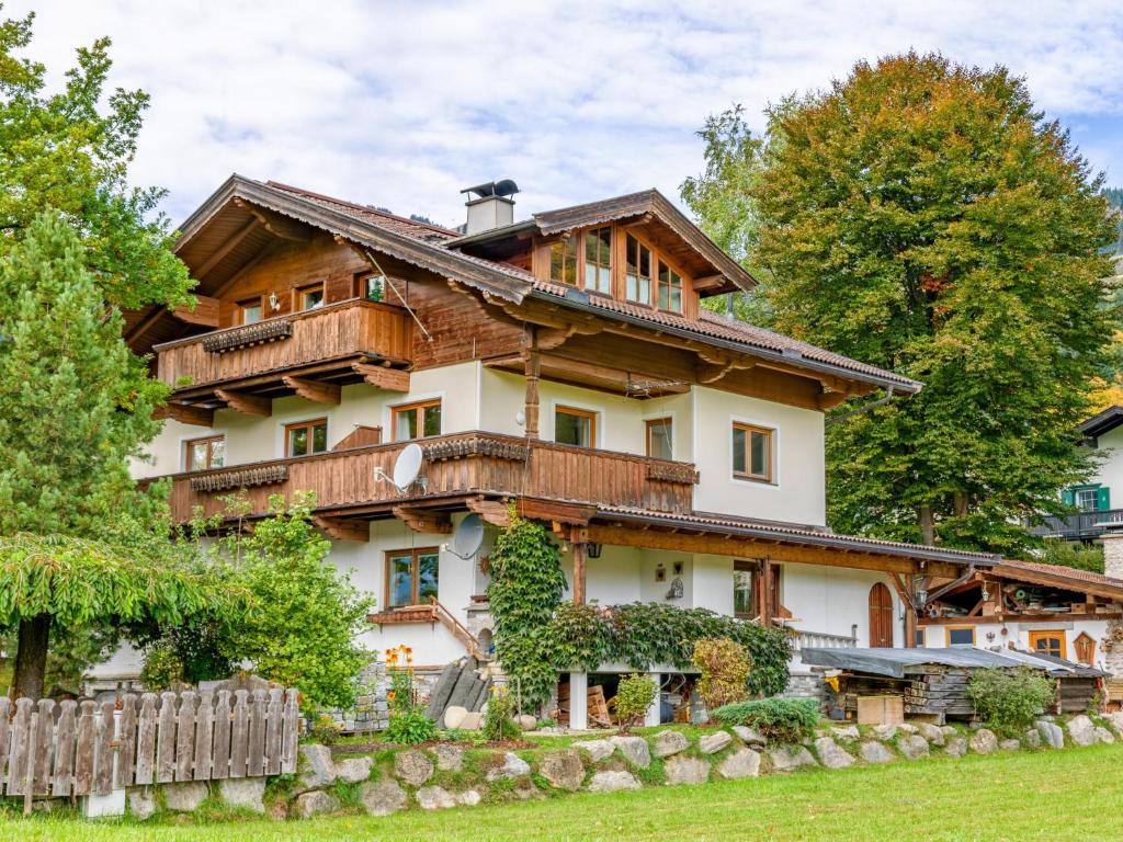 une grande maison en bois avec une clôture devant dans l'établissement Appartement Brixnerwirt II, à Brixen im Thale