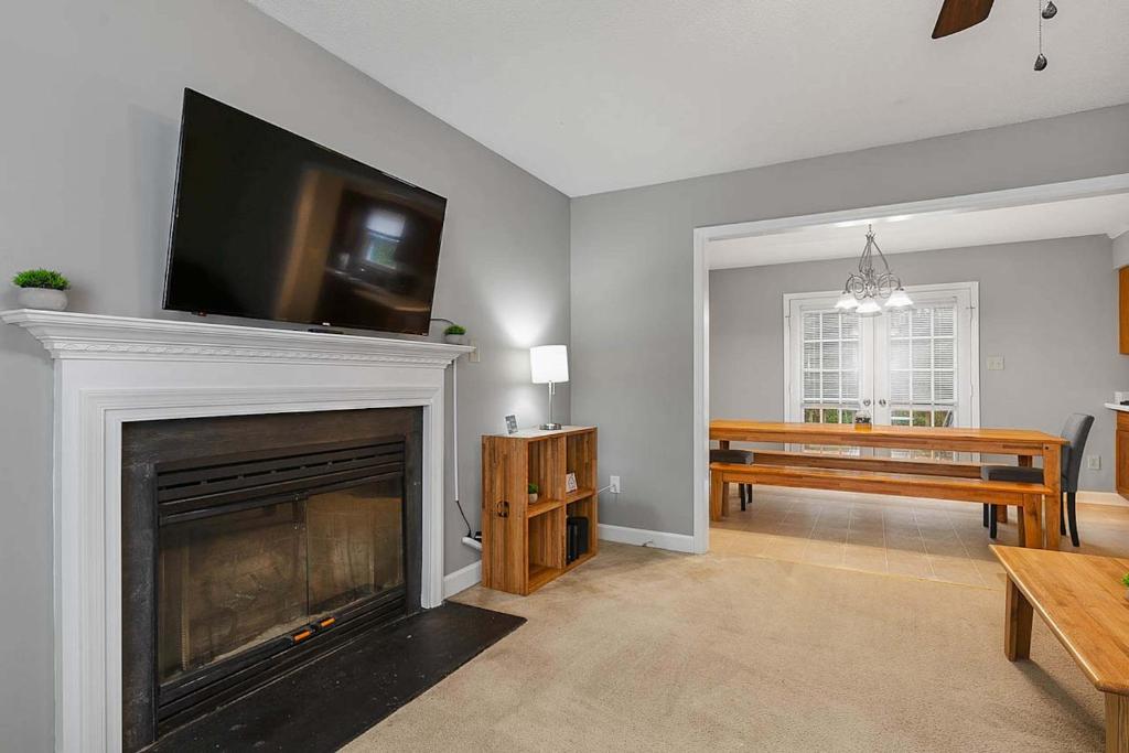 Una sala de estar con chimenea y un televisor de pantalla plana. en Near Parks Trails & Downtown Raleigh Retreat, en Raleigh