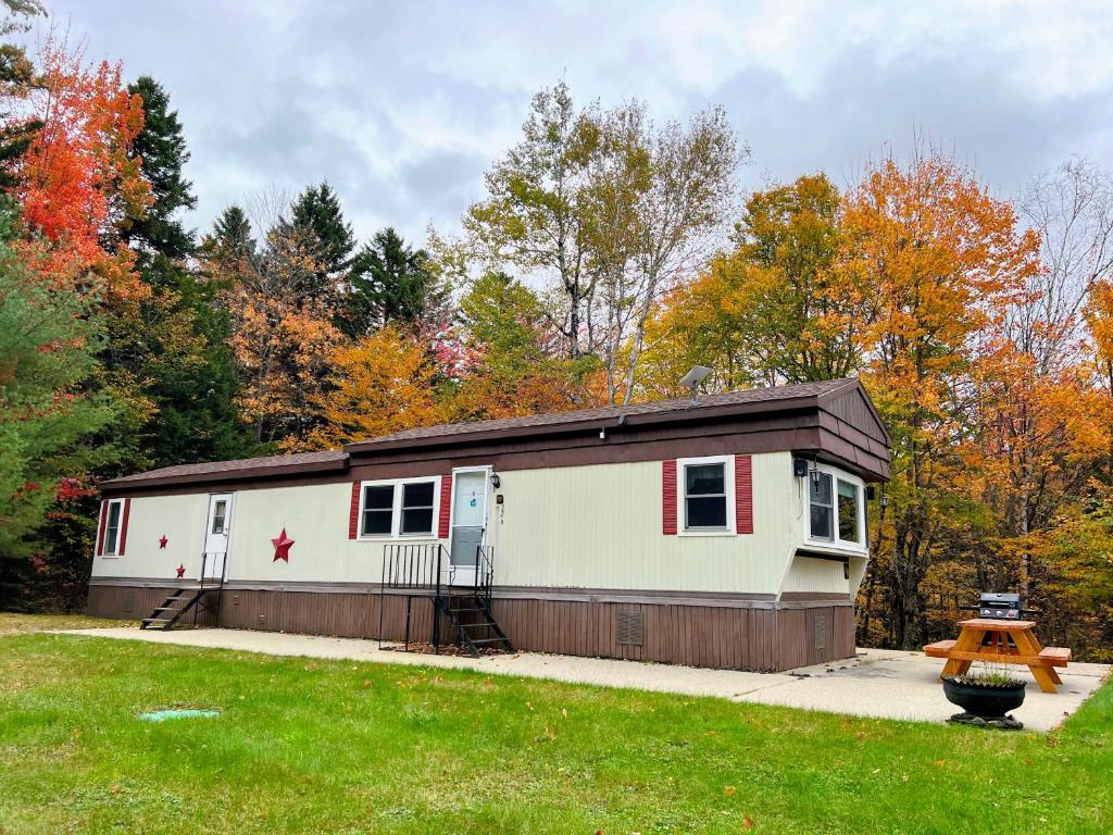 ein kleiner weißer Anhänger mit schwarzem Dach in der Unterkunft 26CM - private camp in Bretton Woods wifi AC private yard with great views in Carroll