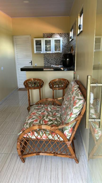 a bench with two chairs in a room with a kitchen at May acomodações in Barreirinhas