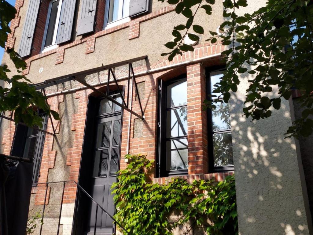 a brick building with four windows and a door at Maison années 30 avec jardin, piscine, proximité Loire, 4 chambres, vélos, idéale familles/amis - FR-1-590-261 in Bonny-sur-Loire