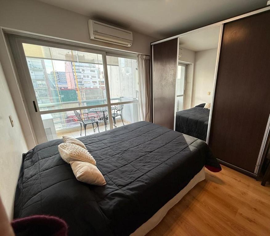ein Schlafzimmer mit einem großen Bett und einem großen Fenster in der Unterkunft RECOLETA A 2 CUADRAS AVENIDA CORRIENTES ACOGEDOR Apartment in Buenos Aires