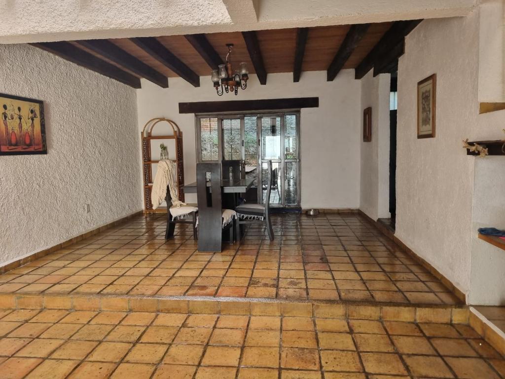 ein Wohnzimmer mit Fliesenboden und einem Fenster in der Unterkunft Casa Marte rústica in Oaxaca de Juárez