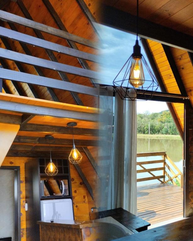 an attic kitchen with a wooden ceiling and lights at Rancho dos lagos in Campo Alegre