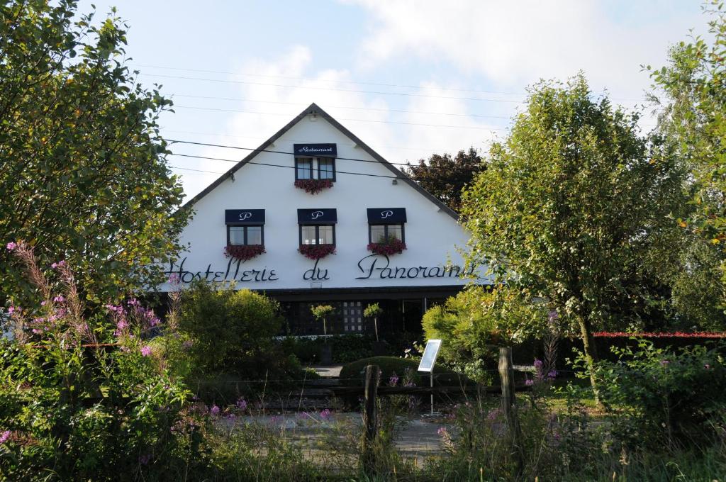 a white house with a sign on the front of it at L'Hostellerie du Panorama in Nadrin