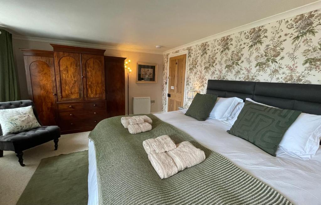 a bedroom with a large bed with towels on it at Treveighan Farmhouse in Saint Teath