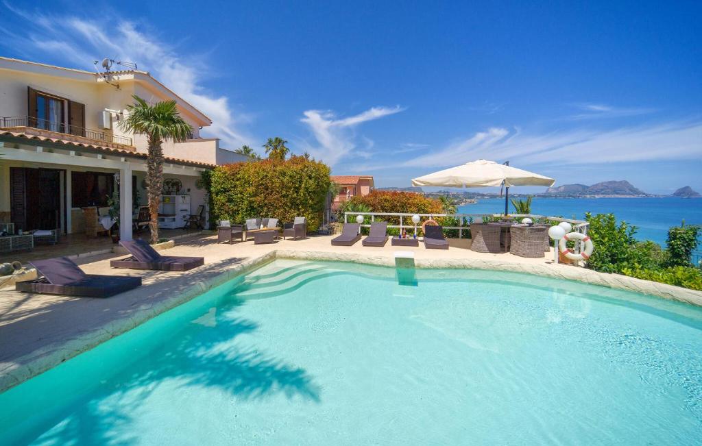 a swimming pool in front of a house at Villa Oceania in Mandra Capreria