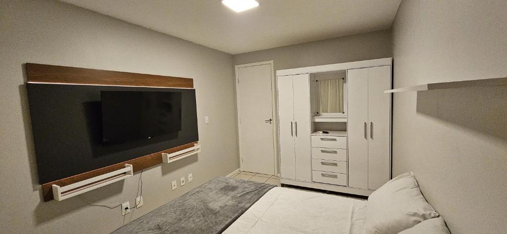 a small room with a tv and a bedroom at Apto 2 Quartos com Suíte, Garagem, 300m da Praia in Fortaleza