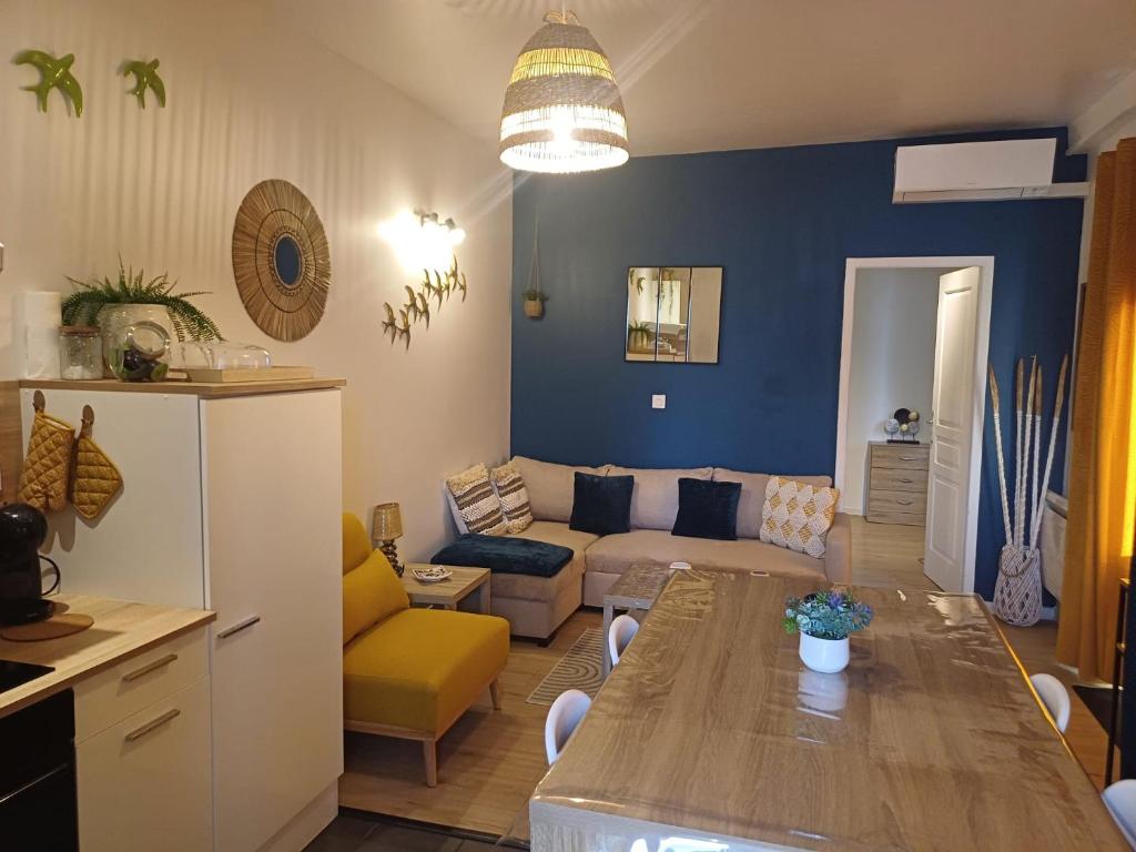 a kitchen and living room with a table and a couch at Au cœur de Sens in Sens