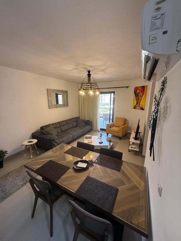 een woonkamer met een tafel en een bank bij 1 Bedroom at Marassi Marina in El Alamein