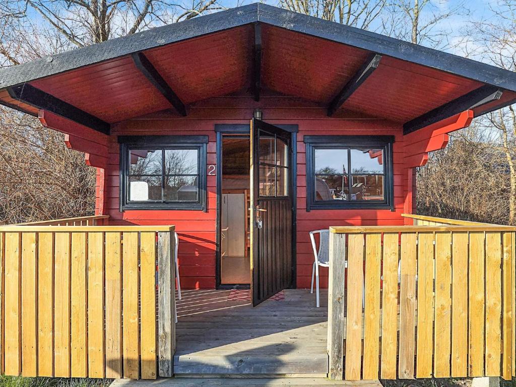 a red house with a wooden door and windows at Holiday home for family Denmark in Gørlev