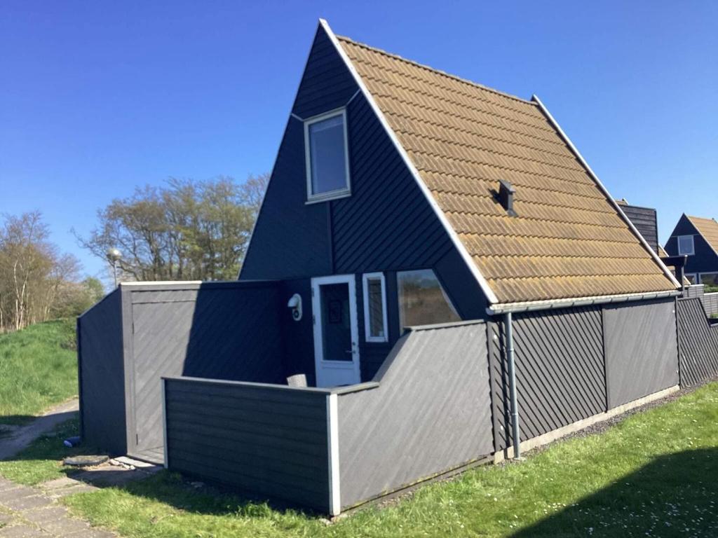 a blue house with a fence around it at 4 person holiday home in Gedser in Gedser