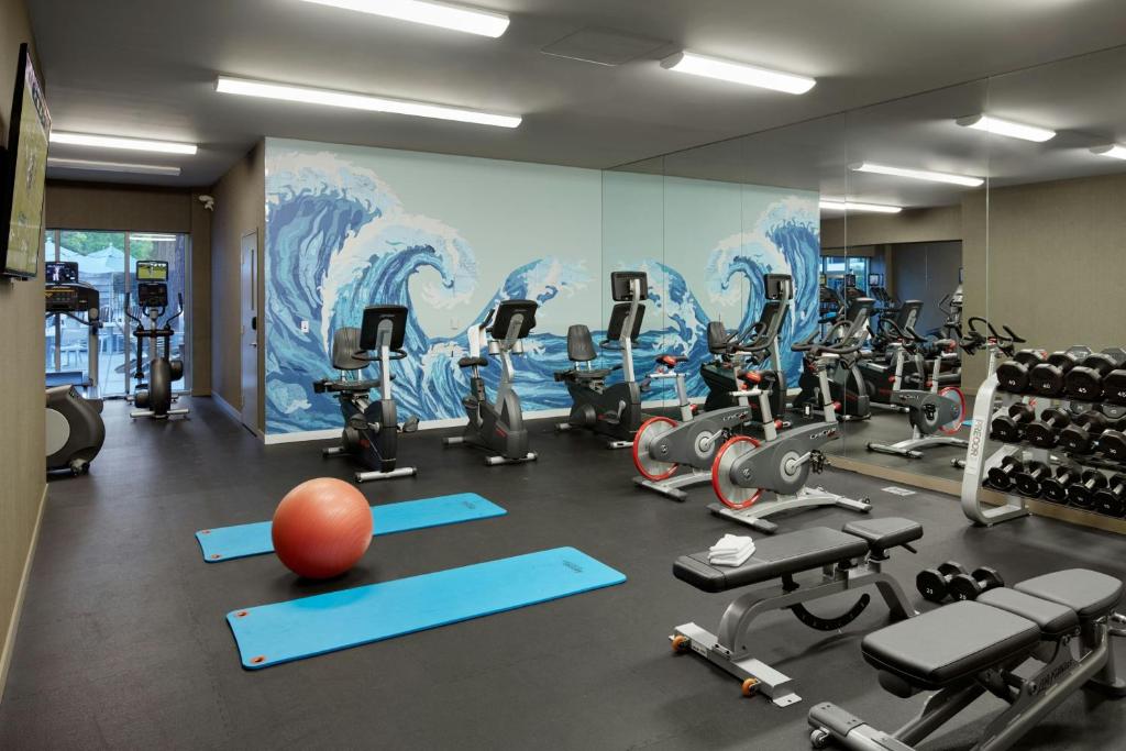 a gym with exercise equipment and a large mural at Hotel Paradox, Autograph Collection in Santa Cruz