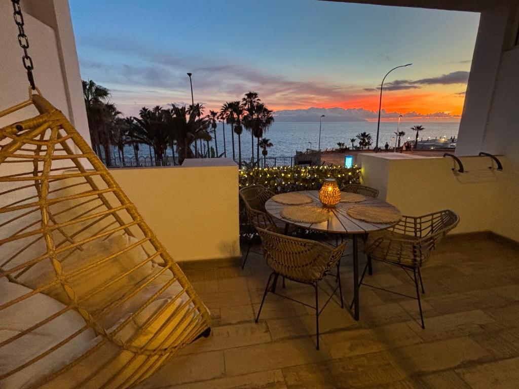 een tafel en stoelen op een balkon met uitzicht op de oceaan bij Callao Sunset Home in Callao Salvaje