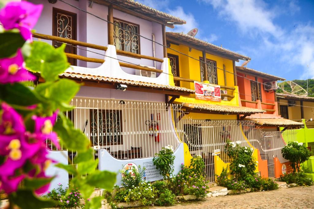 a colorful house with flowers in front of it at Apartamentos Pipa Centro in Pipa