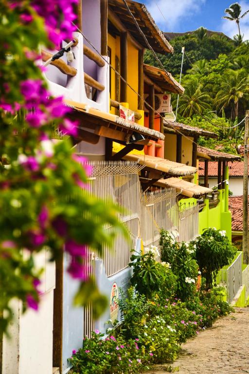 a building with flowers on the side of it at Apartamentos Pipa Centro in Pipa