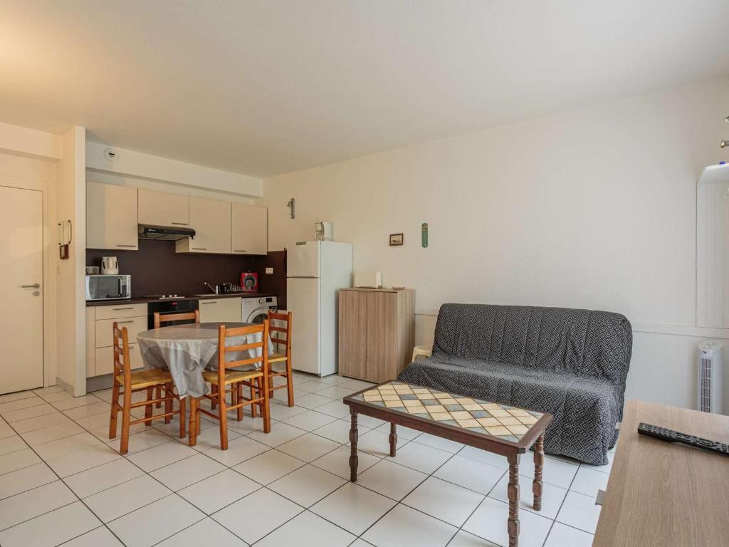ein Wohnzimmer mit Couch und Tisch und eine Küche in der Unterkunft Studio confortable avec jardin et parking à Cambo-les-Bains - FR-1-4-703 in Cambo-les-Bains