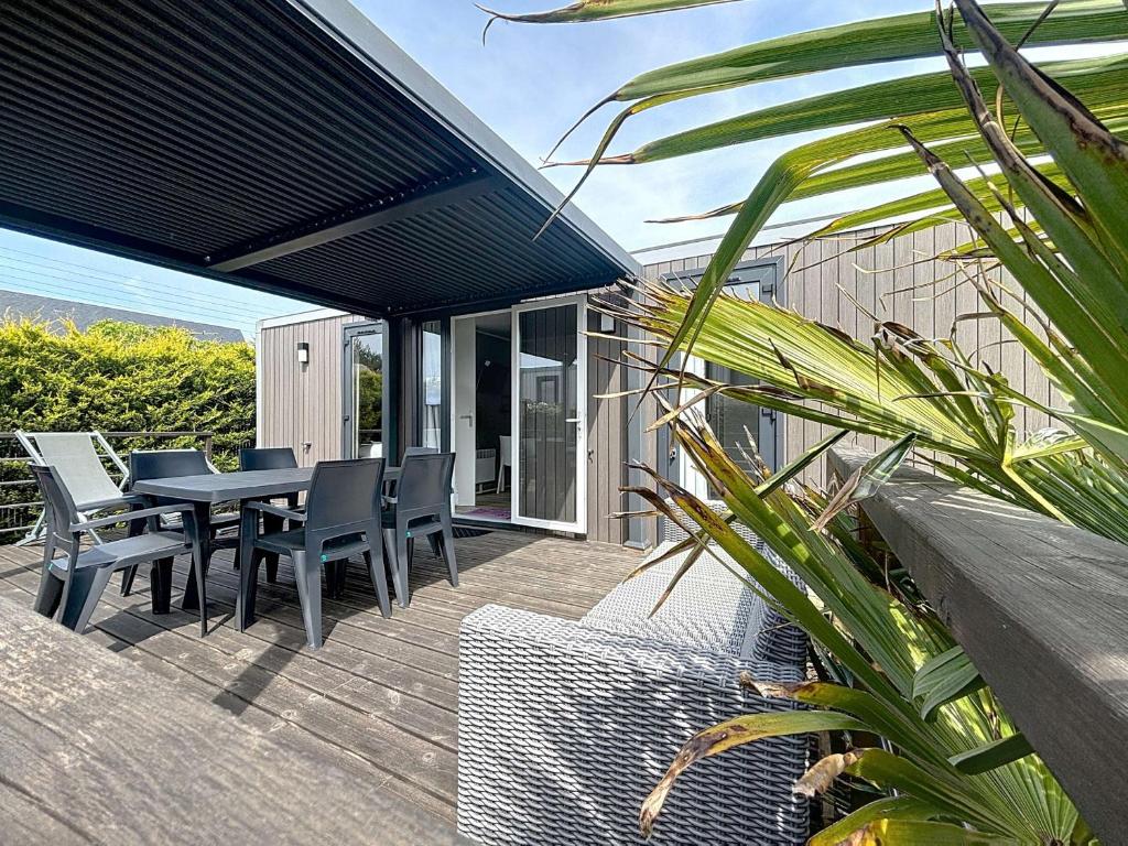 une terrasse avec une table et des chaises sur une maison dans l'établissement Mobil-home Grand Confort: 2 ch, piscine, plage à 200m, parking, wifi - FR-1-361A-96, à Jullouville