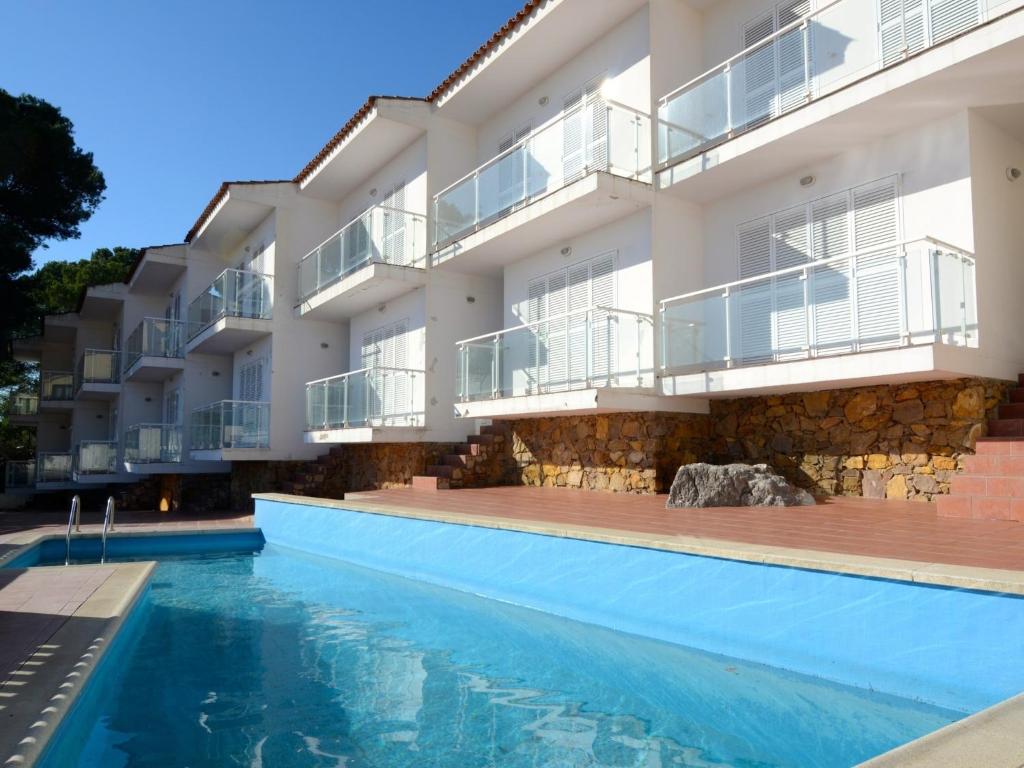 an apartment building with a swimming pool in front of it at Spacious duplex Apartment in Estartit in L'Estartit