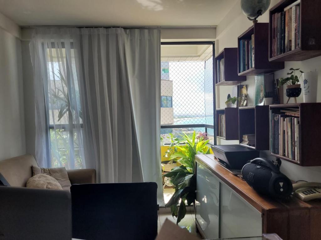 a living room with a desk and a window at Apartamento Vista Mar Belli Golden tower in Natal