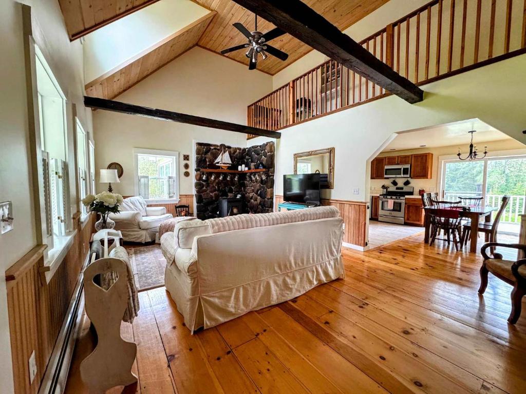 a living room with a couch and a dining room at Pine and Sea Beach Retreat in Ellsworth