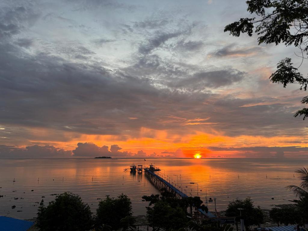 a sunset over a body of water with a dock at Jlb resort and tours,Guest House in Valdez
