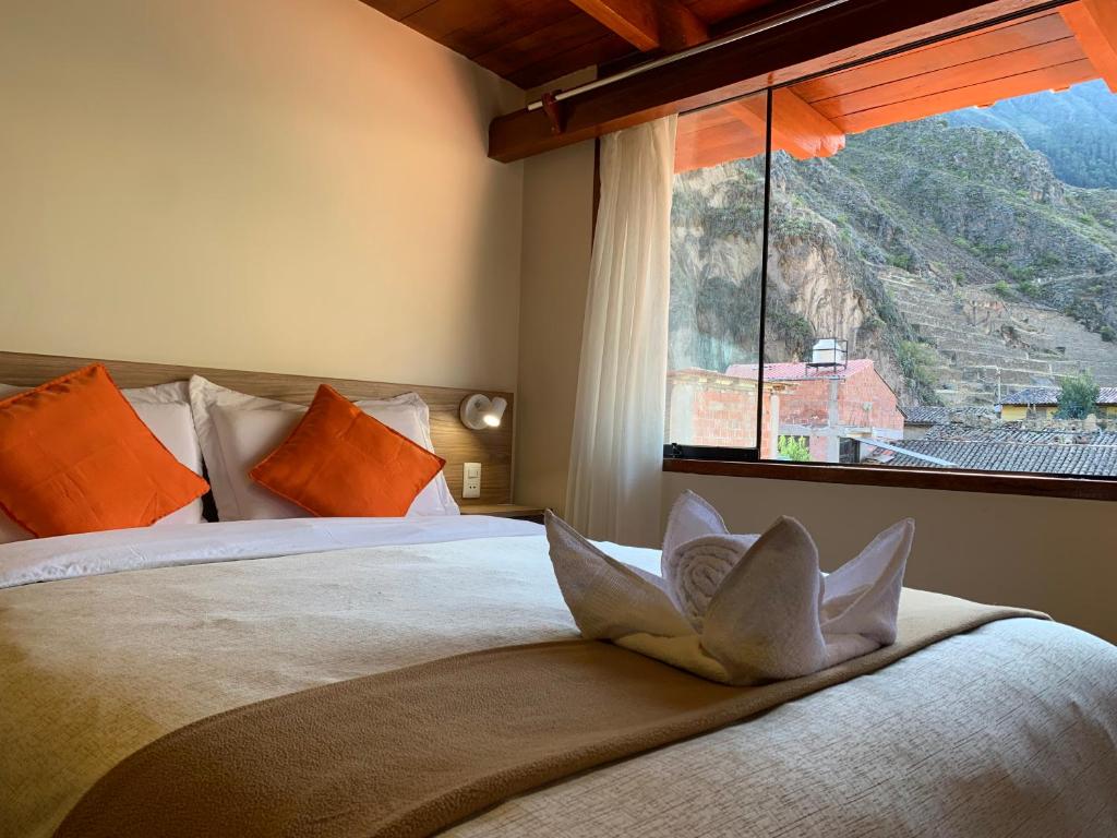 ein Schlafzimmer mit einem Bett mit einem großen Fenster in der Unterkunft Juliet's House in Ollantaytambo