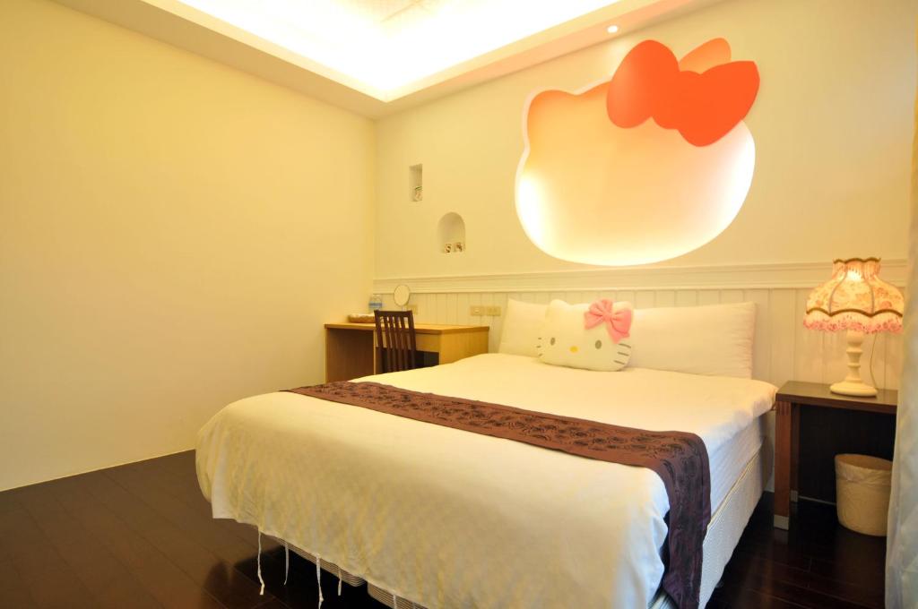 1 dormitorio con 1 cama con una pegatina de manzana en la pared en 朝日民宿 可包棟, en Taitung