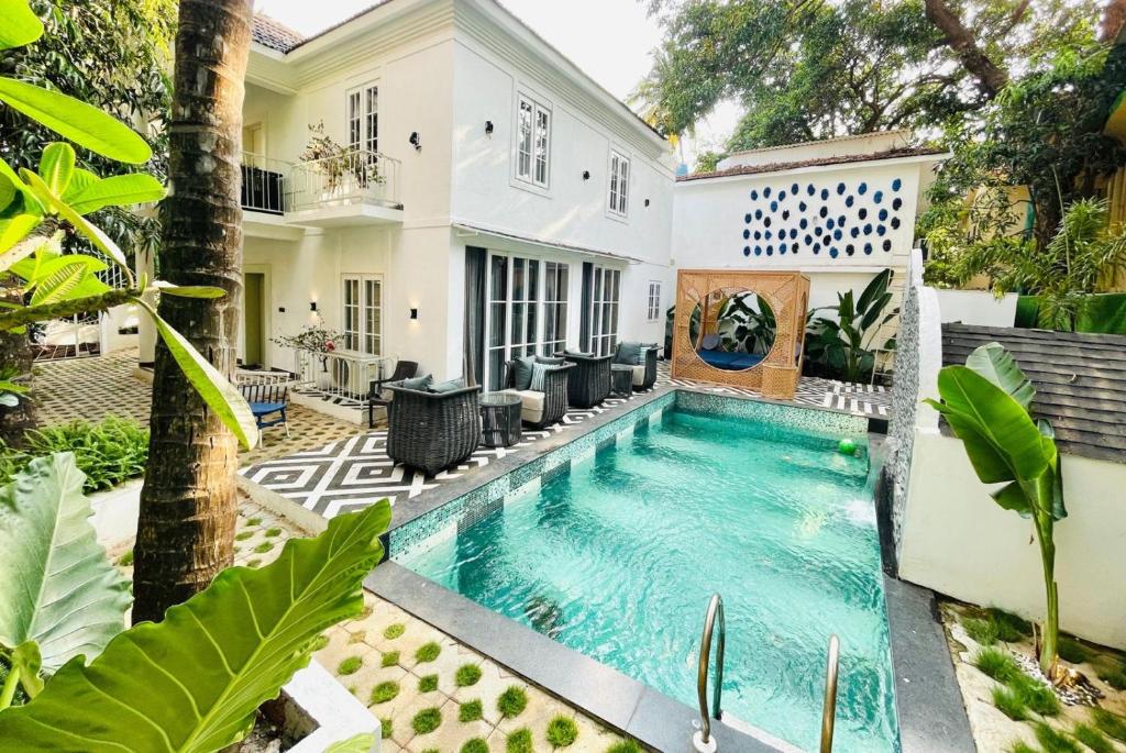 a swimming pool in the backyard of a house at Finca - the tidal nest in Candolim