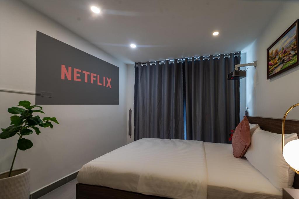 a bedroom with a bed with a netflix sign on the wall at Galaxy Boutique Sai Gon Central Hotel in Ho Chi Minh City