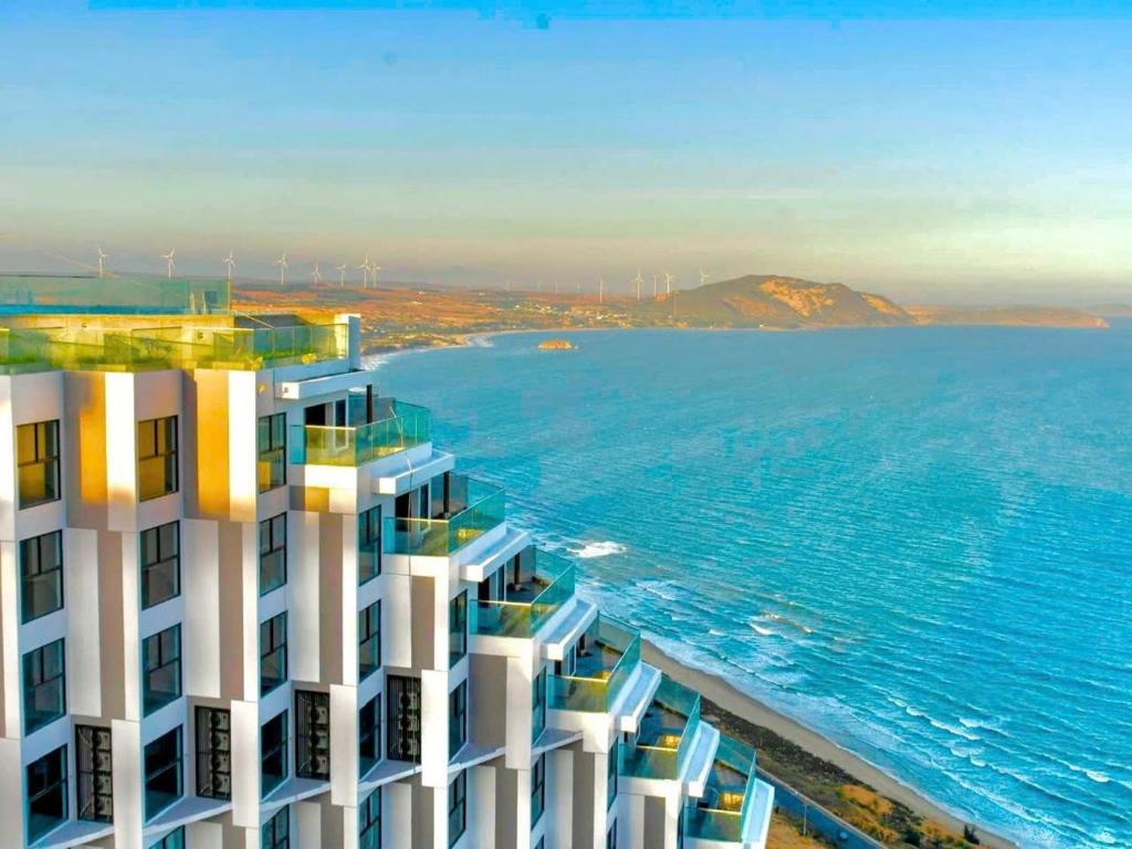 Mandala Beachfront Mui Ne - TanThanh Condotel في موي ني: اطلالة جوية على مبنى مجاور للمحيط