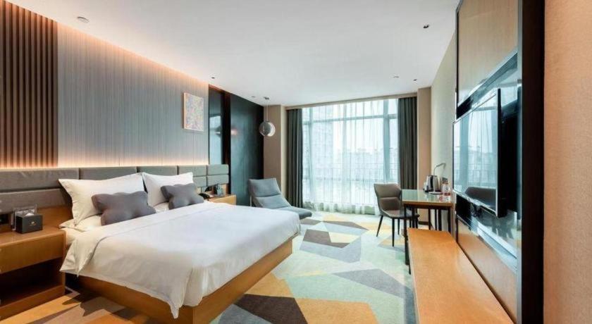 a hotel room with a bed and a television at Chonpines Hotel Guangzhou Sunac Cultural and Tourism City Shiling in Huadu