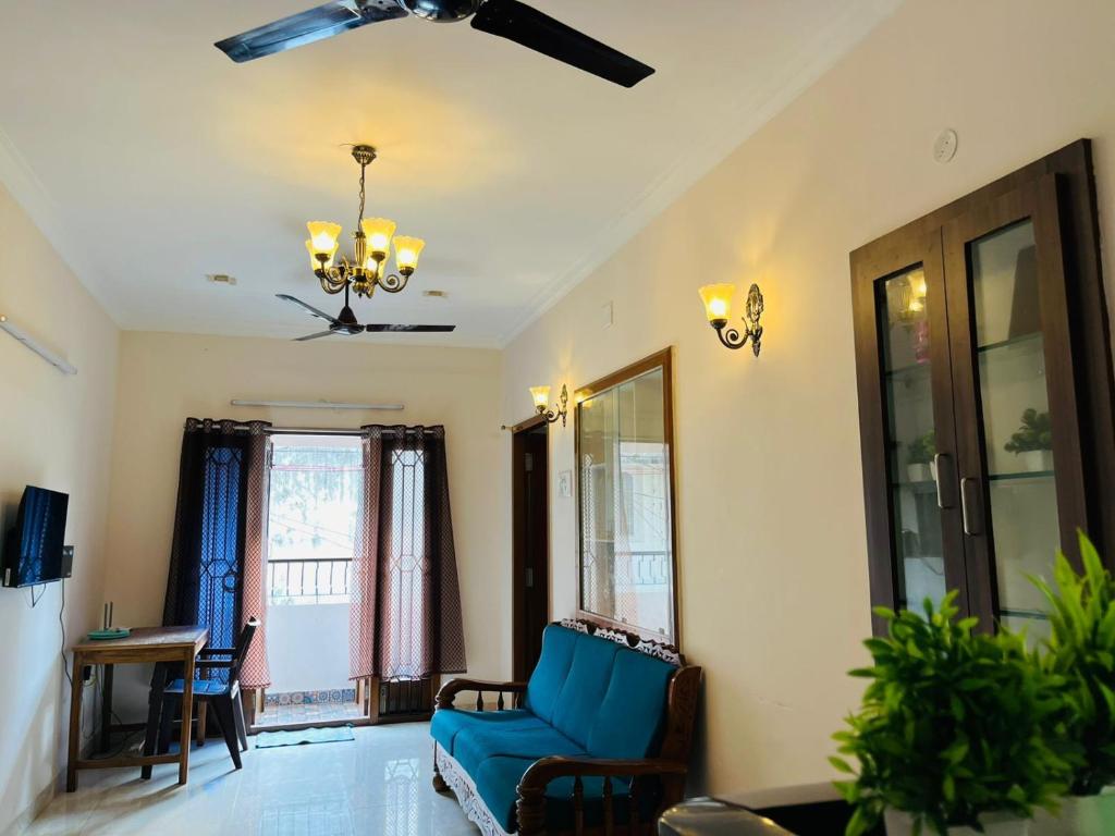 a living room with a blue couch and a ceiling fan at Good stay TNagar in Chennai