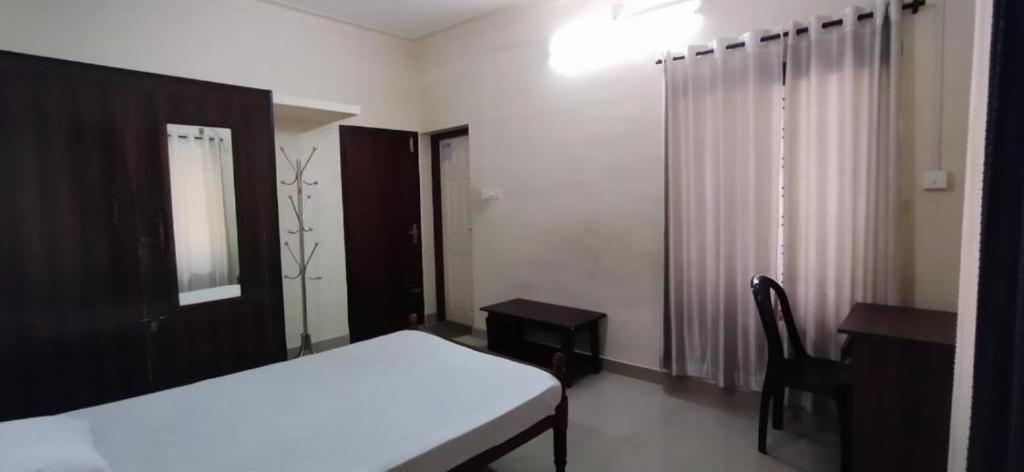 Un dormitorio con una cama, un escritorio y una silla. en AryaBhadhra Cottages 4 Room - 3, en Kochi