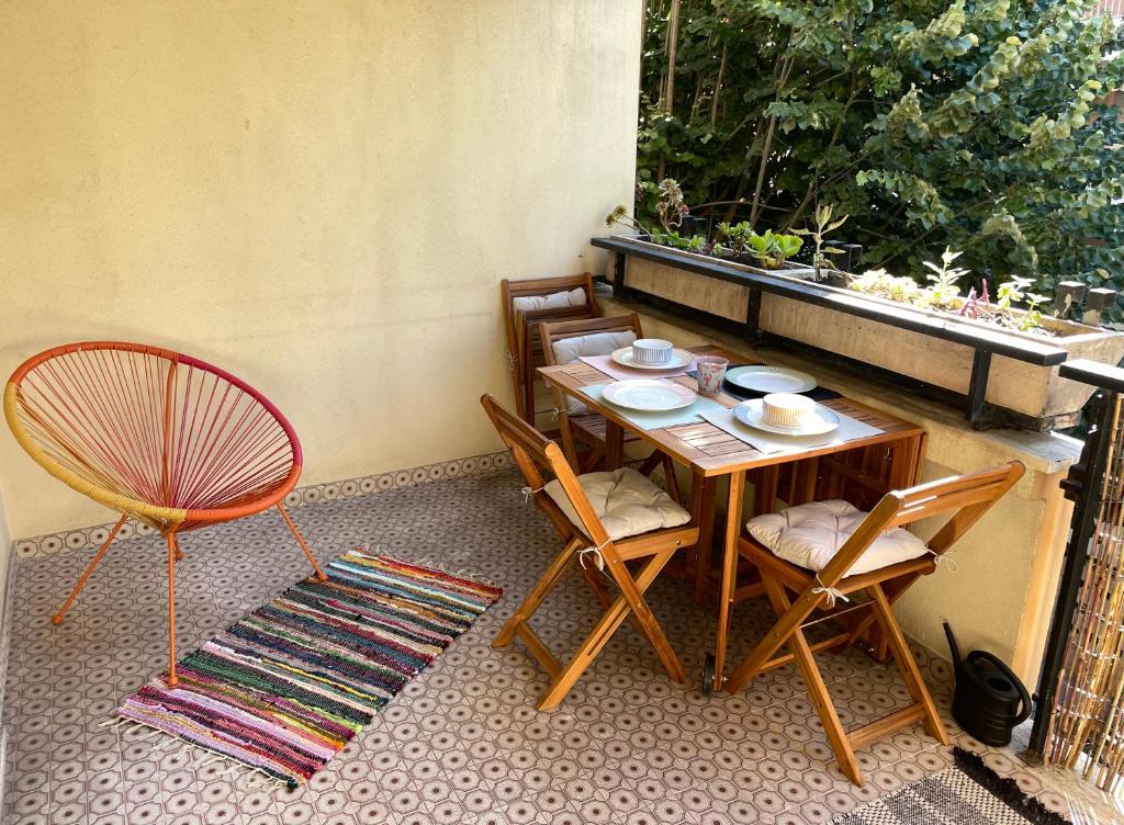 - une table et des chaises sur une terrasse couverte avec une fenêtre dans l'établissement Centre Juan Les Pins studio La Goelette terrasse, à Antibes